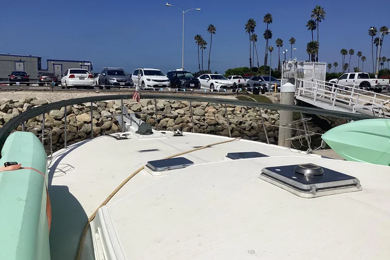 No Reservations Yacht Photos Pics 1984 Spindrift 52 Motor Yacht docked, with cars and palm trees in the background.