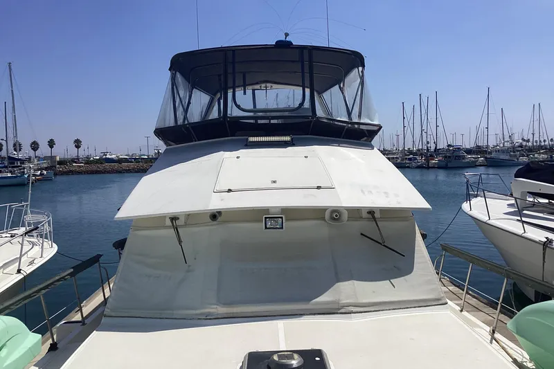 No Reservations Yacht Photos Pics 1984 Spindrift 52 Motor Yacht docked in a marina, surrounded by sailboats.