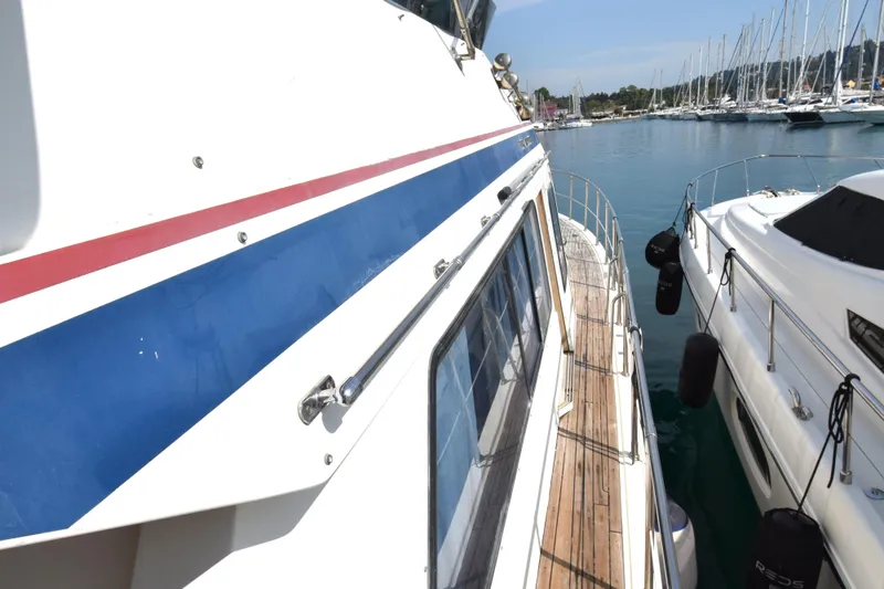 Odyssey Yacht Photos Pics Trader Sunliner 625 yacht, 2000 model, docked in a marina with clear blue water.