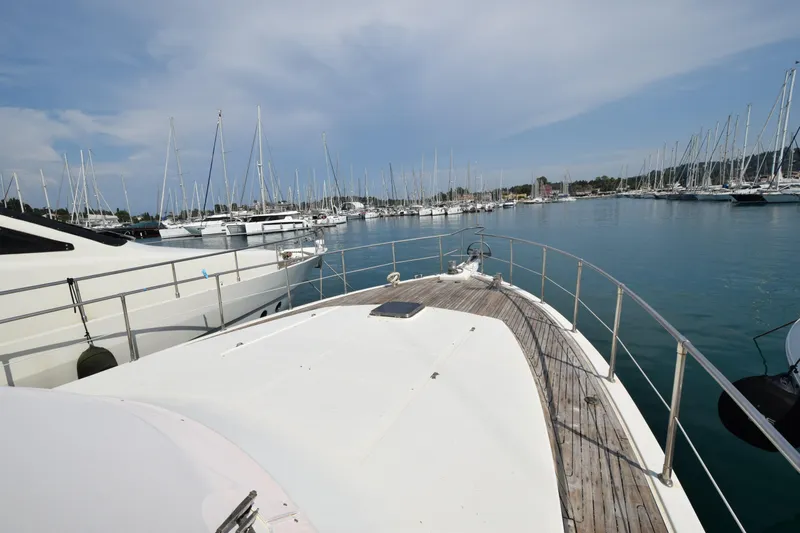 Odyssey Yacht Photos Pics Trader Sunliner 625 yacht in marina, surrounded by sailboats, under a clear sky.