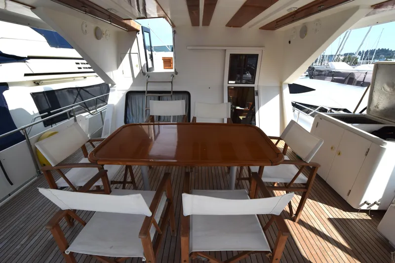 Odyssey Yacht Photos Pics Spacious deck area on 2000 Trader Sunliner 625 yacht with dining table and chairs.