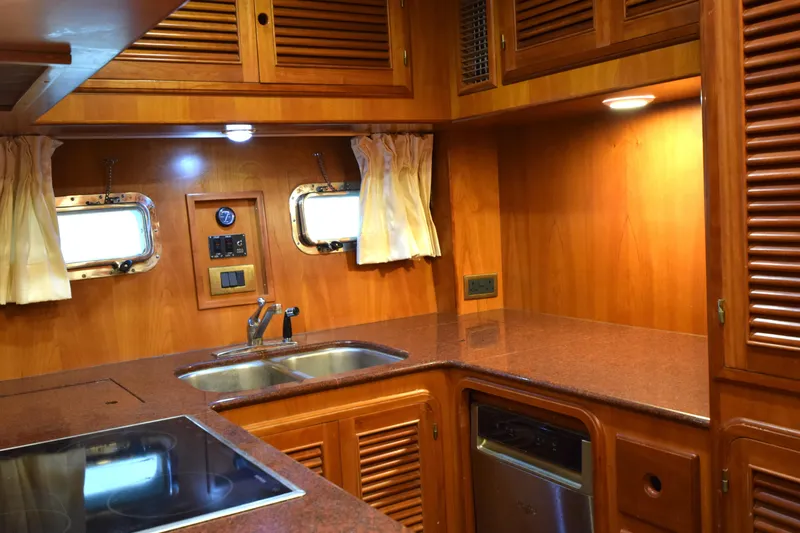Odyssey Yacht Photos Pics Luxurious kitchen interior of 2000 Trader Sunliner 625 yacht with wooden cabinetry and modern appliances.
