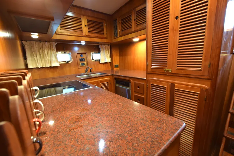 Odyssey Yacht Photos Pics Luxurious wooden kitchen interior of 2000 Trader Sunliner 625 yacht with granite countertops.