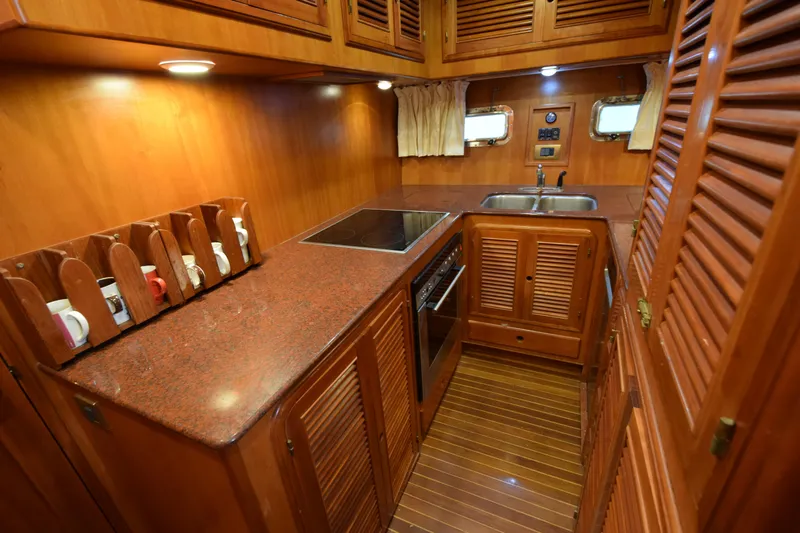 Odyssey Yacht Photos Pics Luxurious wooden kitchen interior of 2000 Trader Sunliner 625 yacht with modern amenities.