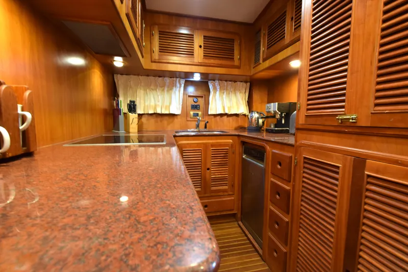 Odyssey Yacht Photos Pics Luxurious wooden kitchen interior of 2000 Trader Sunliner 625 yacht with modern appliances.