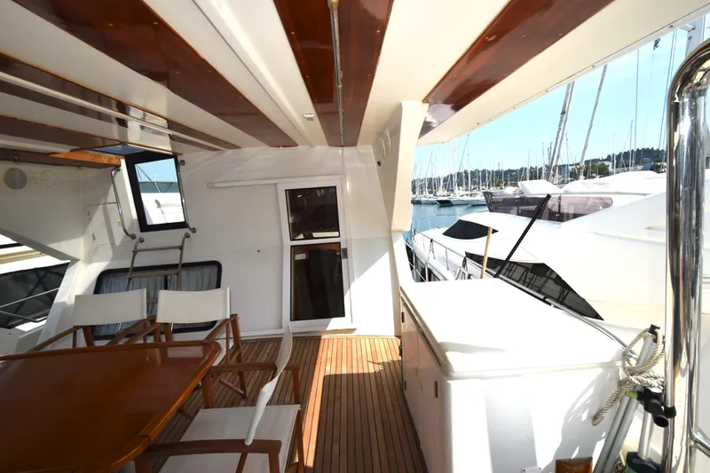 Odyssey Yacht Photos Pics Spacious deck of 2000 Trader Sunliner 625 yacht with wooden furniture and marina view.