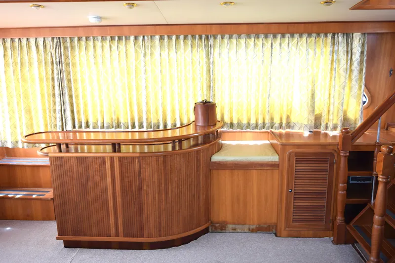 Odyssey Yacht Photos Pics Luxurious interior of 2000 Trader Sunliner 625 yacht with wooden furnishings and elegant curtains.