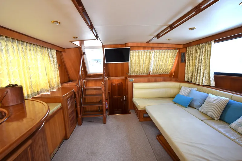 Odyssey Yacht Photos Pics Luxurious interior of 2000 Trader Sunliner 625 yacht with cozy seating and elegant wood finish.