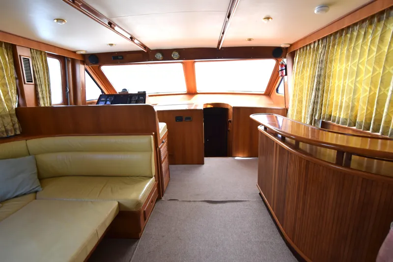 Odyssey Yacht Photos Pics Interior of 2000 Trader Sunliner 625 yacht with wood paneling and yellow seating.