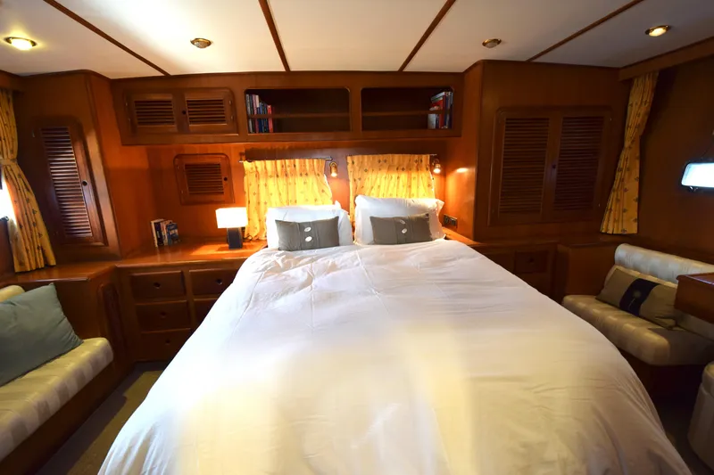 Odyssey Yacht Photos Pics Luxurious cabin interior of 2000 Trader Sunliner 625 yacht with cozy bed and wooden furnishings.