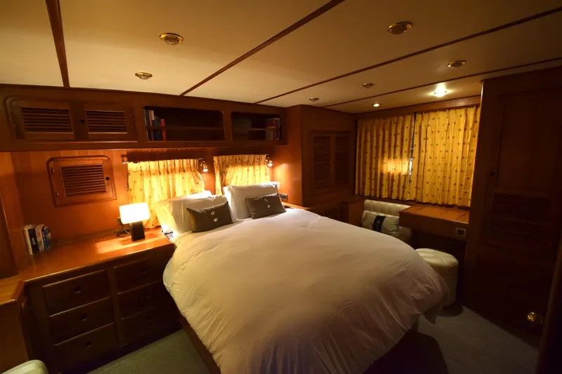 Odyssey Yacht Photos Pics Luxurious cabin interior of 2000 Trader Sunliner 625 yacht with cozy bed and wooden furnishings.