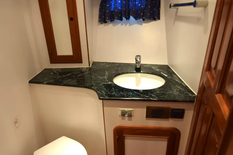 Odyssey Yacht Photos Pics Bathroom interior of 2000 Trader Sunliner 625 with marble countertop and wooden accents.