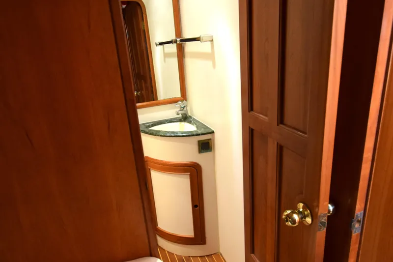 Odyssey Yacht Photos Pics Wooden interior of 2000 Trader Sunliner 625 yacht bathroom with sink and mirror.