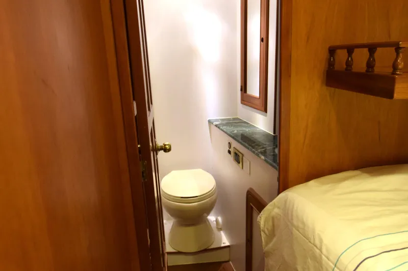 Odyssey Yacht Photos Pics Interior of 2000 Trader Sunliner 625 yacht showing compact bathroom and adjacent bed.