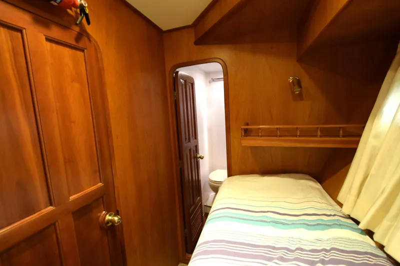 Odyssey Yacht Photos Pics Cozy cabin interior of 2000 Trader Sunliner 625 yacht with wooden paneling and bed.