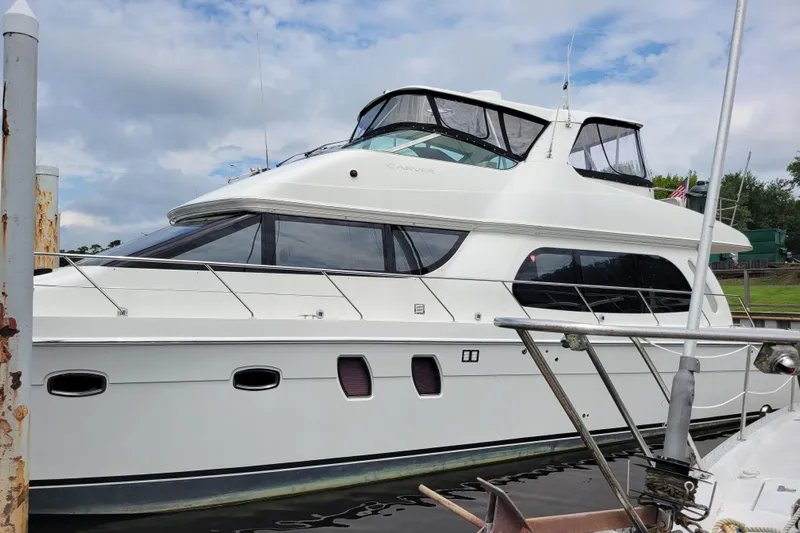  Yacht Photos Pics 2007 Carver 56 Voyager SE yacht docked, showcasing sleek design and spacious upper deck.