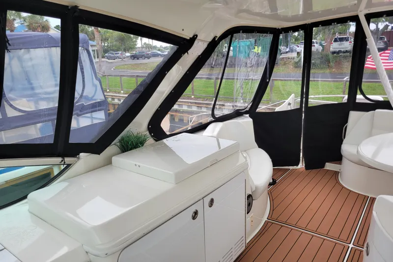  Yacht Photos Pics 2007 Carver 56 Voyager SE yacht interior with seating and windows, docked near greenery.