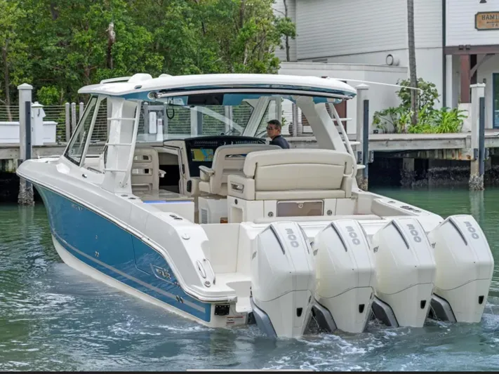 Hightide Yacht Photos Pics 2022 Boston Whaler 380 Realm boat with four engines, docked near a marina.