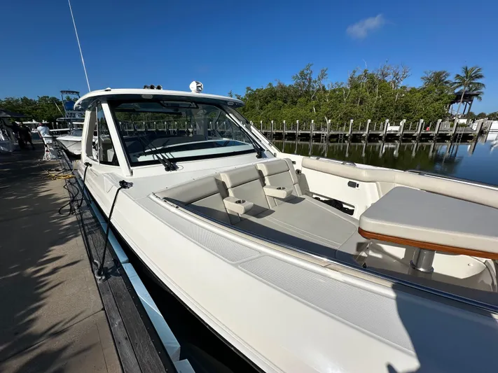 Hightide Yacht Photos Pics 2022 Boston Whaler 380 Realm boat docked, featuring sleek design and spacious seating area.