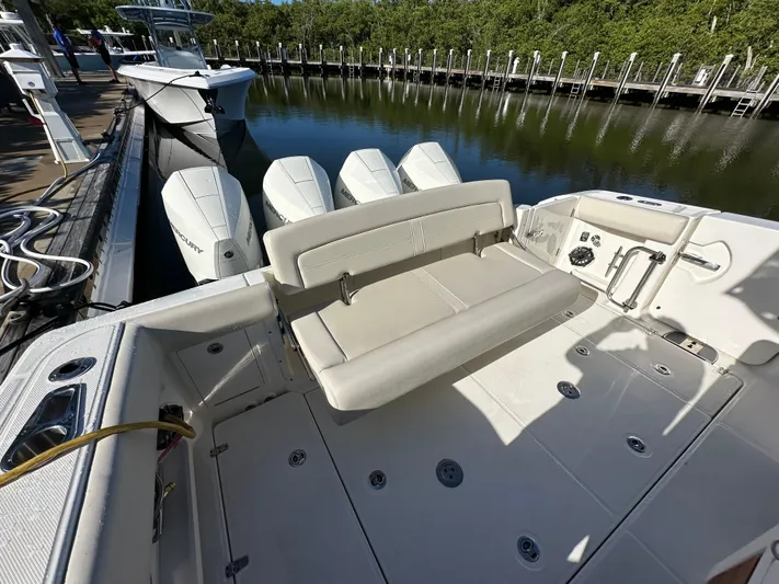 Hightide Yacht Photos Pics 2022 Boston Whaler 380 Realm boat with triple Mercury engines, docked in a marina.