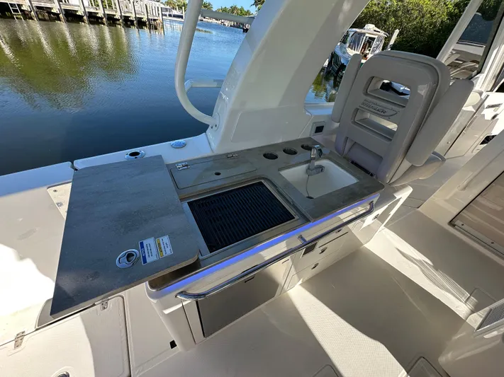 Hightide Yacht Photos Pics Boston Whaler 380 Realm 2022 boat with outdoor kitchen and sink by the water.
