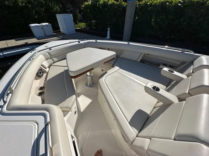 Hightide Yacht Photos Pics 2022 Boston Whaler 380 Realm boat interior with cushioned seating and table.