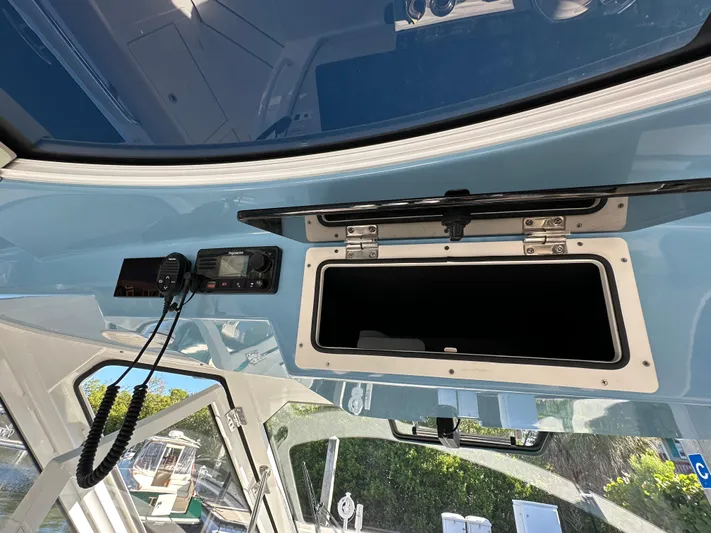 Hightide Yacht Photos Pics Boston Whaler 380 Realm 2022 boat interior with open storage compartment and radio equipment.