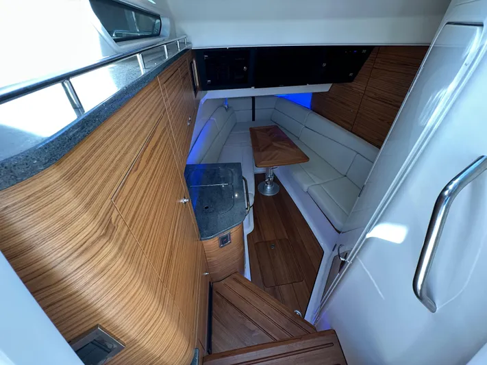 Hightide Yacht Photos Pics Interior of 2022 Boston Whaler 380 Realm, featuring wood finishes and a cozy seating area.