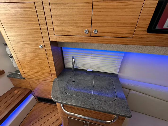 Hightide Yacht Photos Pics 2022 Boston Whaler 380 Realm interior with wooden cabinetry and modern sink area.