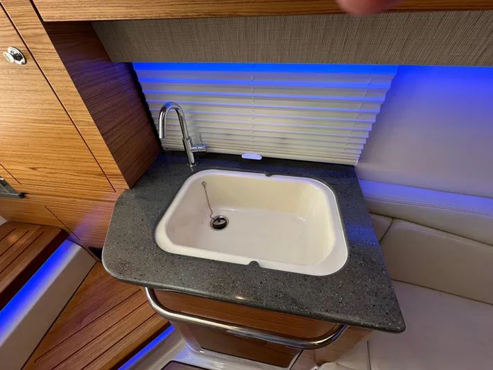 Hightide Yacht Photos Pics Luxury sink area on 2022 Boston Whaler 380 Realm boat with modern design and blue lighting.