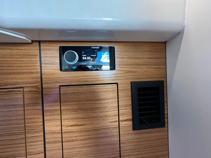 Hightide Yacht Photos Pics 2022 Boston Whaler 380 Realm interior with Fusion stereo system and wood paneling.