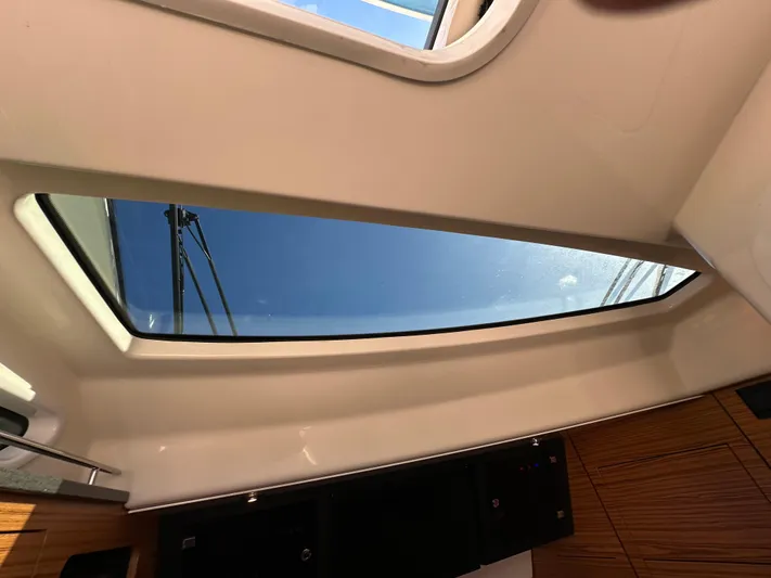 Hightide Yacht Photos Pics Interior view of 2022 Boston Whaler 380 Realm, featuring a skylight and wooden cabinetry.