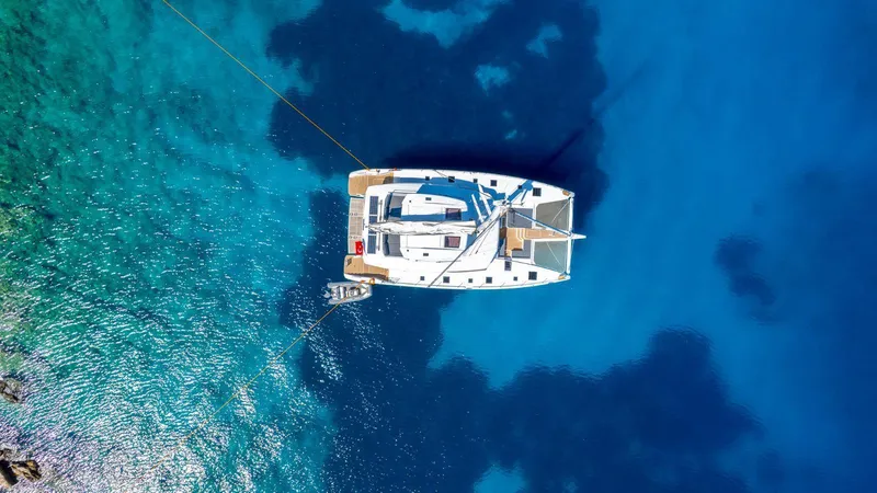  Yacht Photos Pics Aerial view of 2023 Fountaine Pajot Catamaran Alegria 67 on clear blue water.