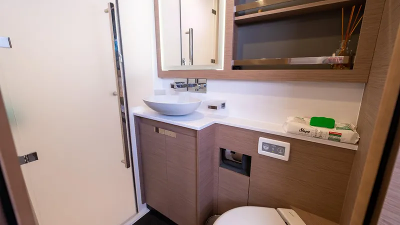  Yacht Photos Pics Modern bathroom in 2023 Fountaine Pajot Catamaran Alegria 67 with sleek fixtures and wood accents.