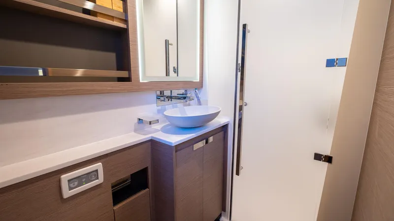  Yacht Photos Pics Modern bathroom interior on 2023 Fountaine Pajot Catamaran Alegria 67, featuring sleek sink and cabinetry.