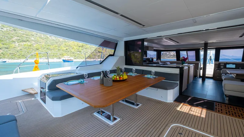  Yacht Photos Pics Luxurious interior of 2023 Fountaine Pajot Catamaran Alegria 67 with dining area and scenic view.