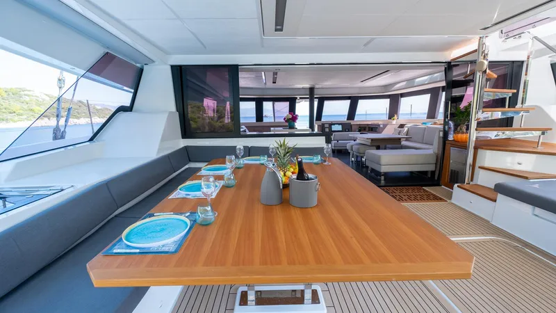  Yacht Photos Pics Luxurious interior of 2023 Fountaine Pajot Catamaran Alegria 67 with elegant dining area.