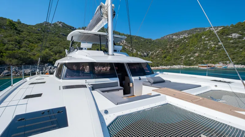  Yacht Photos Pics 2023 Fountaine Pajot Catamaran Alegria 67 sailing in scenic coastal waters.
