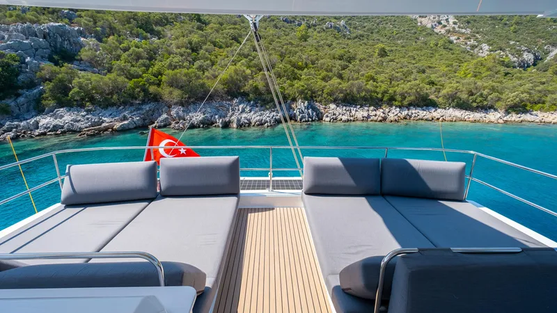  Yacht Photos Pics Luxurious 2023 Fountaine Pajot Catamaran Alegria 67 with sun loungers, scenic coastal view.