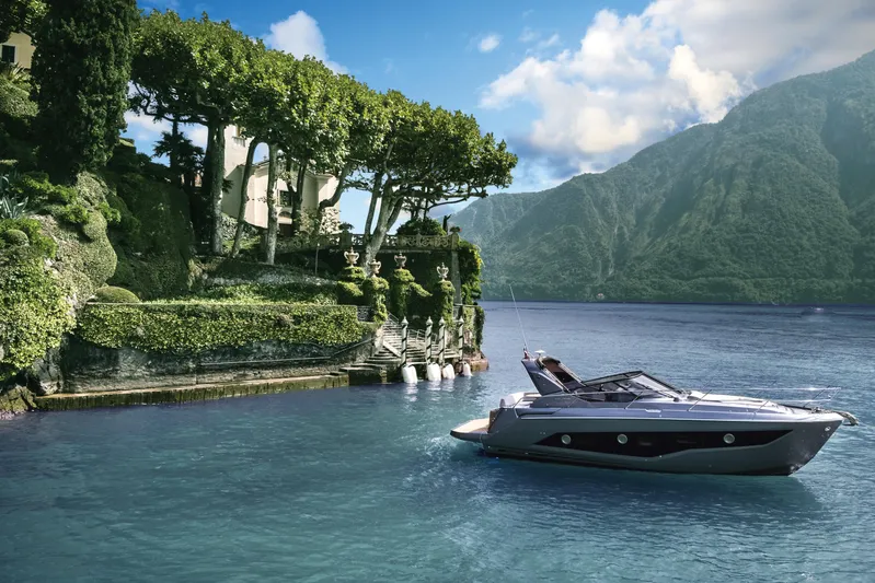  Yacht Photos Pics 2025 Cranchi Z35 yacht cruising near lush, scenic shoreline with mountains in the background.