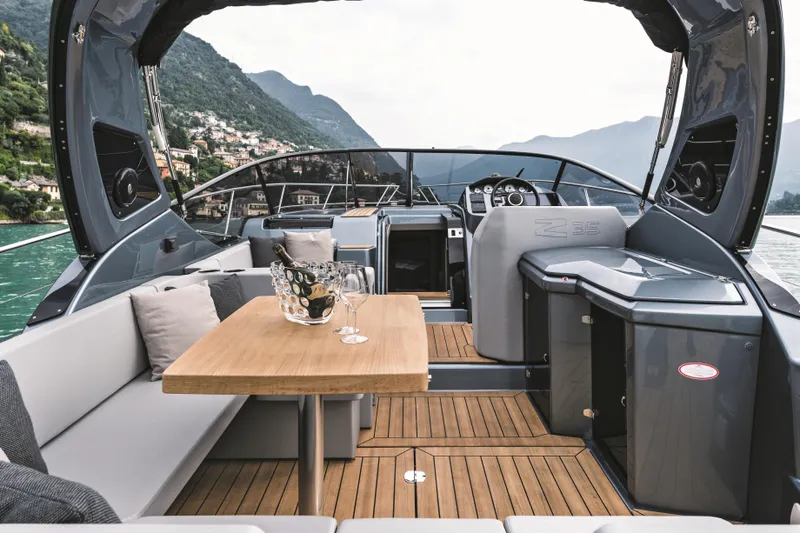  Yacht Photos Pics 2025 Cranchi Z35 yacht interior with elegant seating and wooden table on a scenic lake.