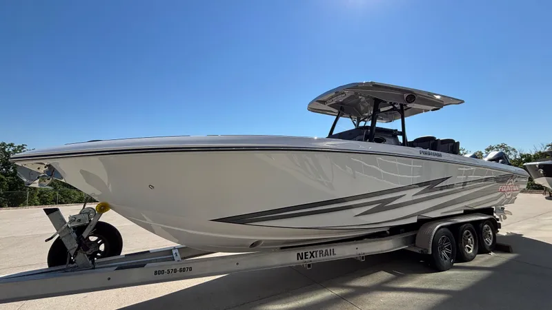  Yacht Photos Pics 2025 Fountain 34 SC boat on trailer under clear blue sky.