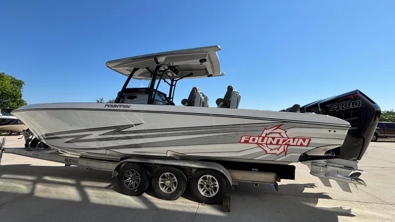  Yacht Photos Pics 2025 Fountain 34 SC boat on trailer, sleek design, powerful engine, clear blue sky background.