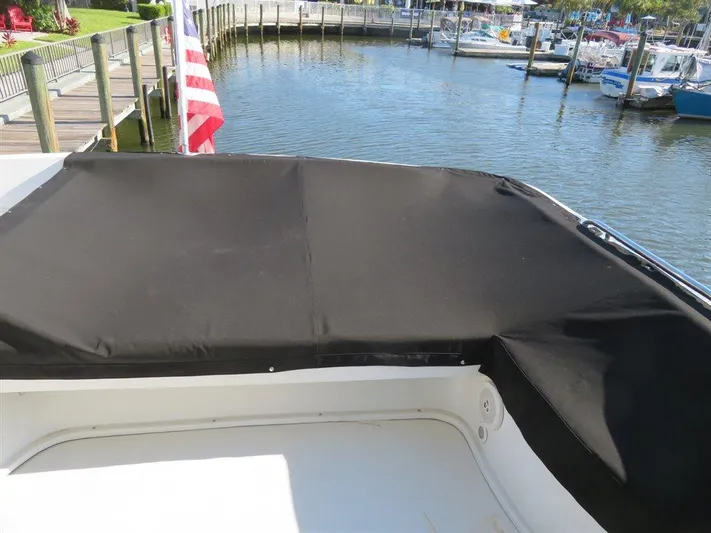  Yacht Photos Pics Bluewater Yachts Millennium Series 63, 2000 model, docked with black cover and American flag.