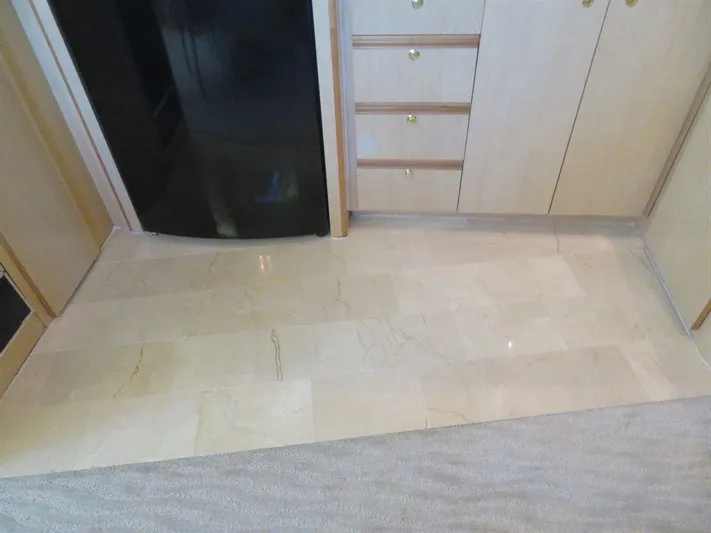  Yacht Photos Pics Interior of 2000 Bluewater Yachts Millennium Series 63 with marble flooring and wooden cabinetry.