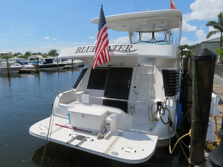  Yacht Photos Pics Bluewater Yachts Millennium Series 63, 2000 model, docked with American flag.