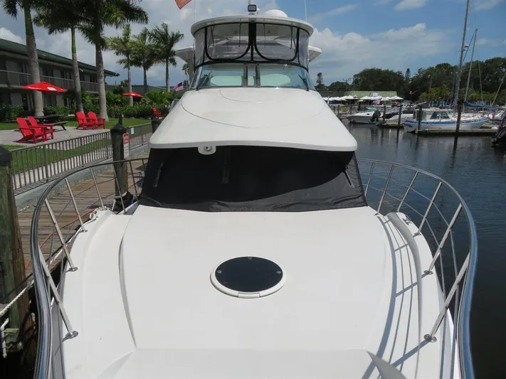  Yacht Photos Pics 2000 Bluewater Yachts Millennium Series 63 docked at marina, surrounded by palm trees.