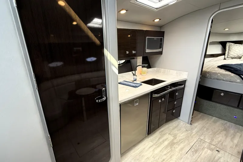 Knot To Scale Yacht Photos Pics Interior of 2018 Formula 37 Performance Cruiser with modern kitchenette and cozy sleeping area.