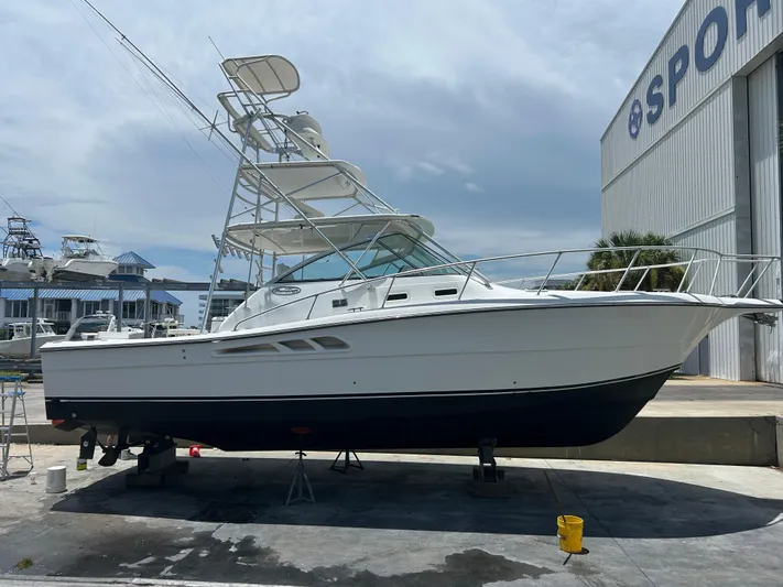 Ironman Yacht Photos Pics 2006 Rampage EXPRESS boat on dry dock near a large building, clear sky background.