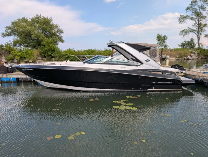  Yacht Photos Pics 2011 Monterey 328 SS boat docked on calm water with trees in the background.